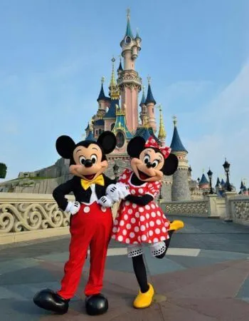 Mickey Mouse and Minnie Mouse posing in front of Cinderella Castle at Magic Kingdom Park in Walt Disney World, Orlando, conveying the joy and magic of a Disney vacation.