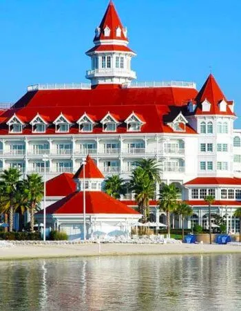El elegante Disney's Grand Floridian Resort & Spa, con sus distintivos techos rojos y arquitectura victoriana en la orilla del lago.
